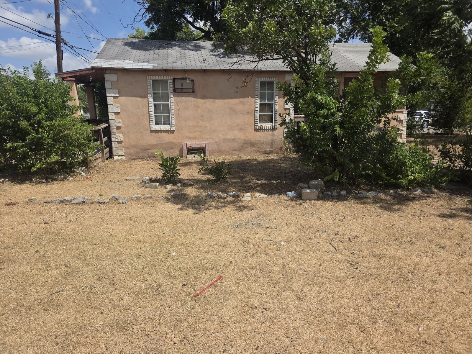 Cleared, cut-back yard with trees beside a San Antonio house